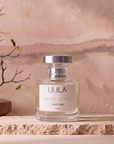 Santal Soirée 50ml parfum styled on travertine against a warm plaster wall