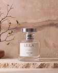 Fumée 50ml parfum styled on travertine against a warm plaster wall