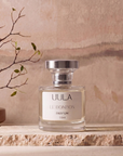 Le Bonbon 50ml parfum styled on travertine against a warm plaster wall
