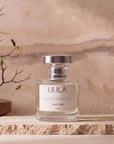 Nude Vanille 50ml parfum styled on travertine against a warm plaster wall